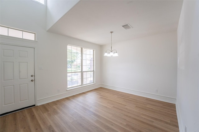 entrance foyer with light wood-type flooring and an inviting chandelier