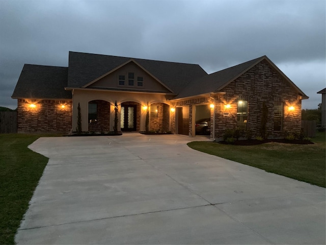 view of front of house with stone siding, driveway, and a front lawn