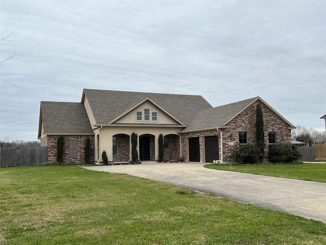 view of front of house with a garage, driveway, fence, and a front yard