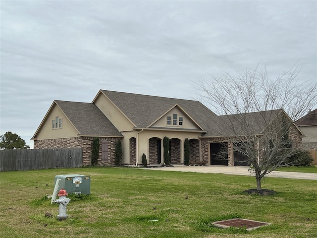 view of front facade with a garage, driveway, a front yard, and stucco siding