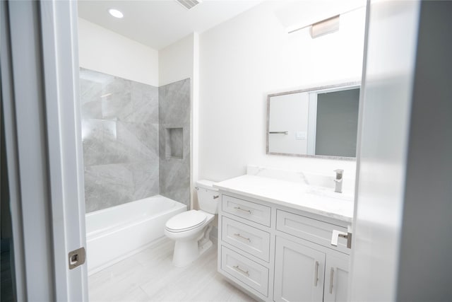 full bathroom featuring tiled shower / bath combo, vanity, and toilet