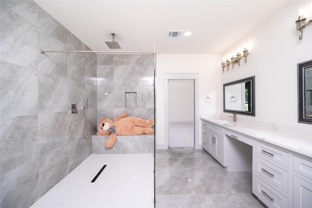 bathroom featuring vanity and tiled shower