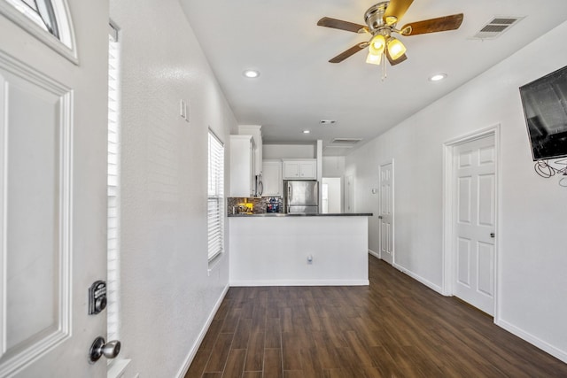 kitchen featuring appliances with stainless steel finishes, ceiling fan, dark hardwood / wood-style flooring, kitchen peninsula, and white cabinets