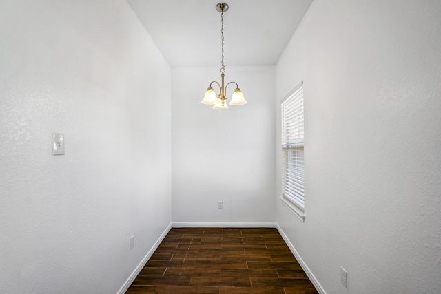 empty room with a chandelier and dark hardwood / wood-style floors