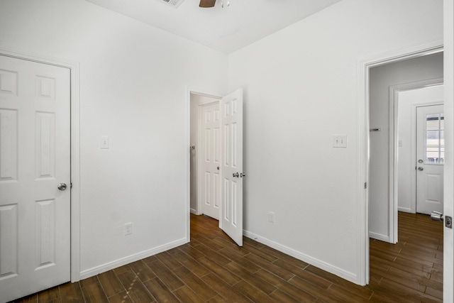 unfurnished bedroom featuring dark hardwood / wood-style floors and ceiling fan