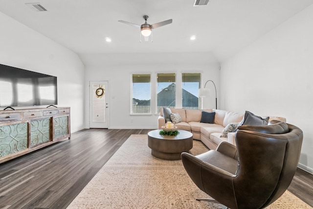 living room featuring dark wood-style flooring, visible vents, and vaulted ceiling