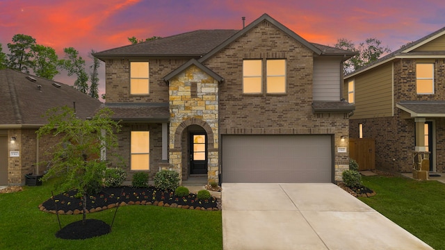 view of front of home featuring driveway, a garage, a lawn, and brick siding