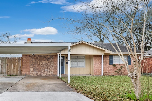 single story home with driveway, fence, a front yard, a carport, and brick siding