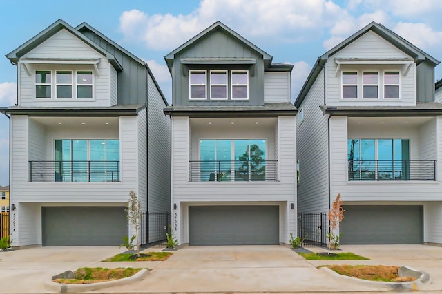 view of front of house with driveway, board and batten siding, an attached garage, and a balcony