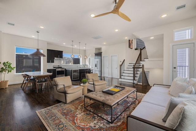 living area featuring visible vents, wine cooler, stairway, dark wood-style flooring, and recessed lighting