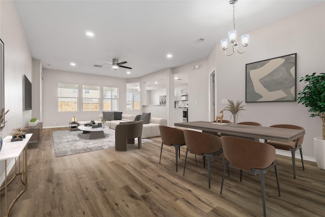 dining space with dark wood-style floors, recessed lighting, visible vents, and baseboards