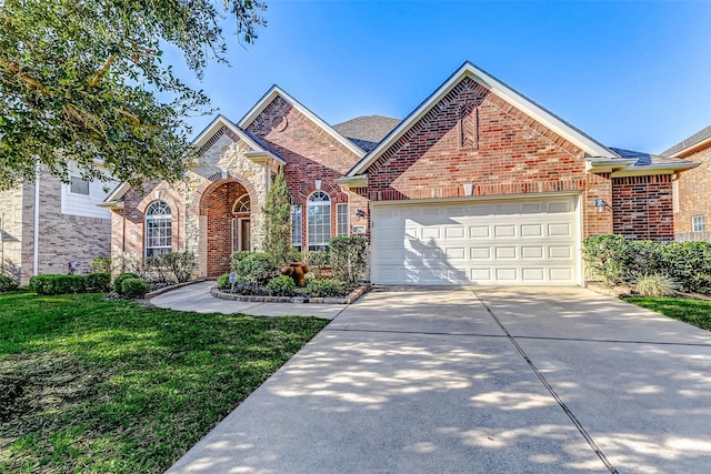 view of front of property featuring a front lawn, brick siding, driveway, and an attached garage