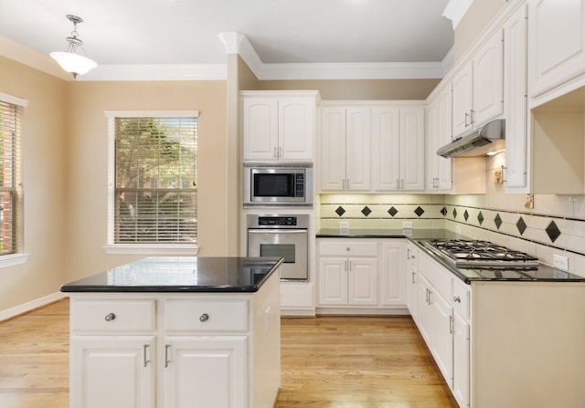 kitchen with decorative light fixtures, stainless steel appliances, dark countertops, white cabinetry, and under cabinet range hood