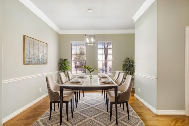 dining space with baseboards, ornamental molding, and wood finished floors