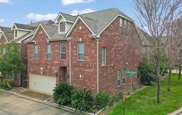 view of front of property with driveway, a garage, a front lawn, and brick siding