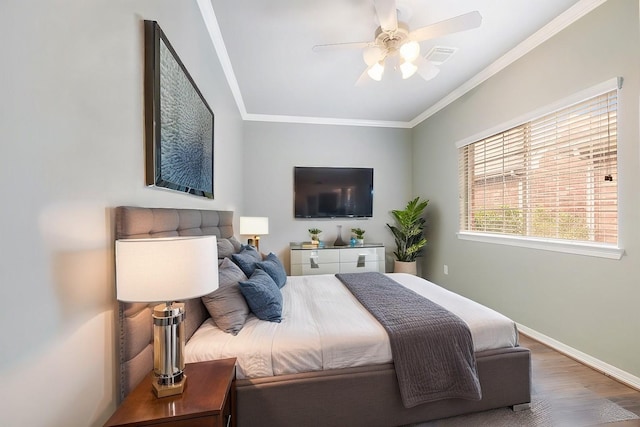 bedroom featuring ceiling fan, ornamental molding, wood finished floors, and baseboards