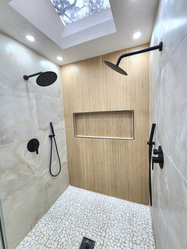 bathroom with a textured ceiling, tiled shower, and recessed lighting