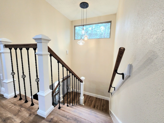 stairway featuring wood finished floors and baseboards