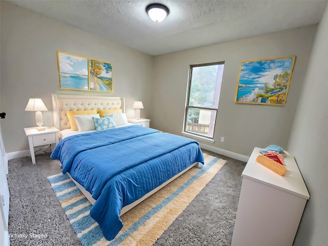 bedroom featuring a textured ceiling, carpet floors, and baseboards