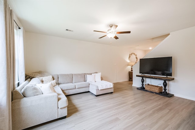 living room with light wood-style flooring, visible vents, and ceiling fan