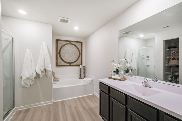 bathroom featuring a stall shower, wood finished floors, and visible vents