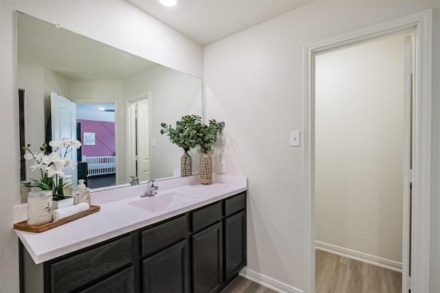 bathroom featuring wood finished floors, vanity, and baseboards