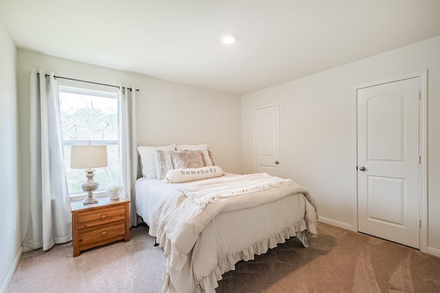 bedroom with baseboards and light colored carpet