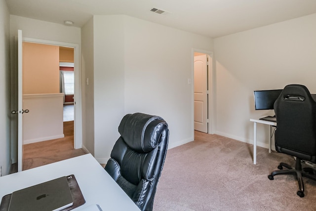 office space with light colored carpet, visible vents, and baseboards