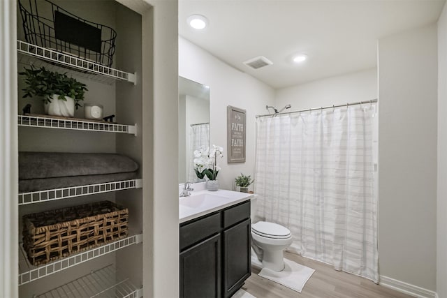 bathroom featuring recessed lighting, vanity, toilet, and wood finished floors