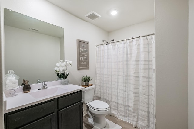 bathroom featuring toilet, visible vents, wood finished floors, and vanity