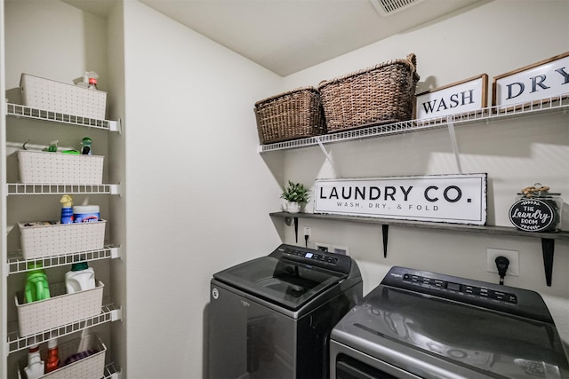 washroom featuring laundry area, separate washer and dryer, and visible vents