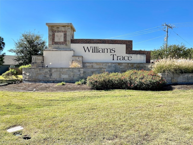 community sign featuring a yard