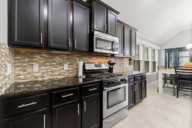 kitchen with tasteful backsplash, vaulted ceiling, stainless steel appliances, crown molding, and light tile patterned flooring