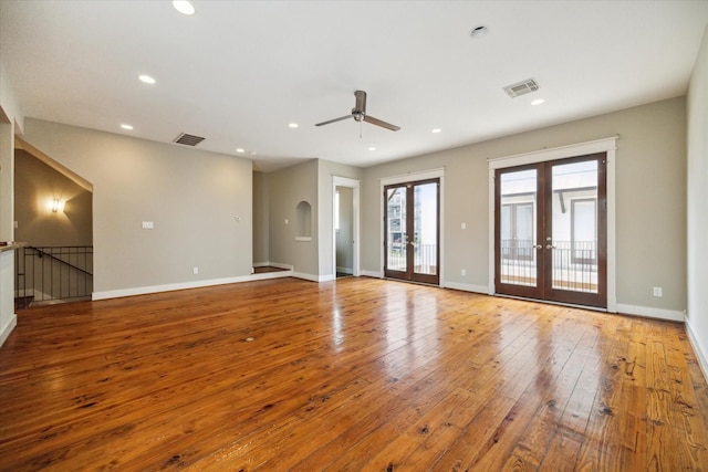 empty room with ceiling fan, light wood-type flooring, and french doors