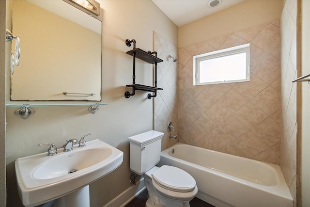 full bathroom featuring tiled shower / bath combo, sink, and toilet