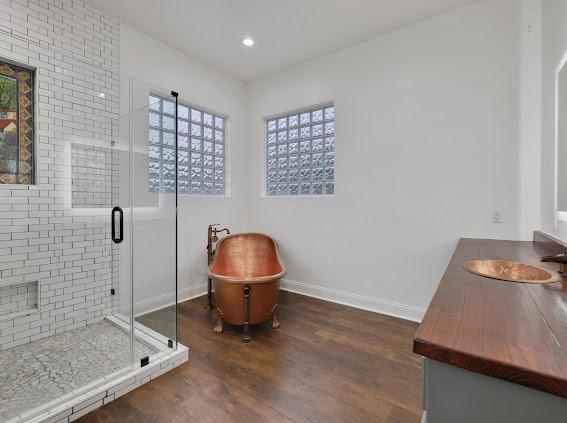 bathroom with vanity, wood-type flooring, and walk in shower