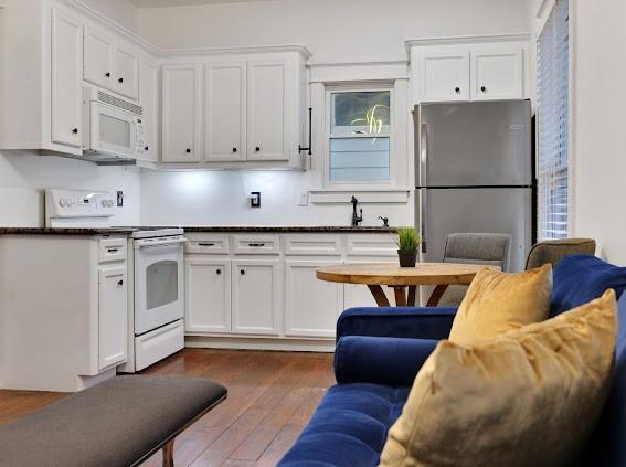 kitchen featuring white appliances, dark hardwood / wood-style flooring, white cabinets, and sink