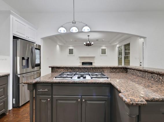 kitchen featuring dark stone countertops, an inviting chandelier, appliances with stainless steel finishes, white cabinetry, and gray cabinetry