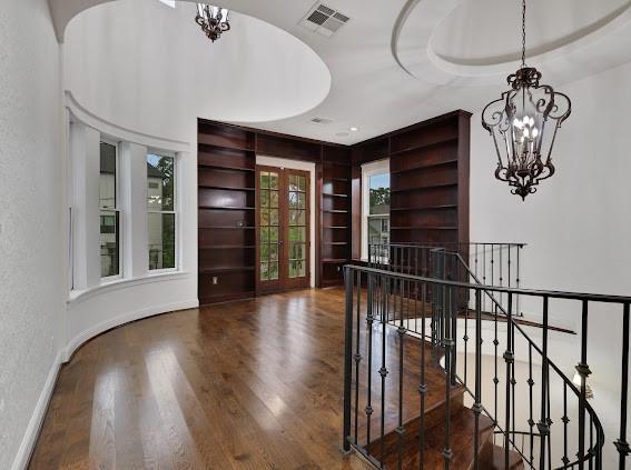 interior space with a tray ceiling, french doors, dark hardwood / wood-style flooring, and a notable chandelier