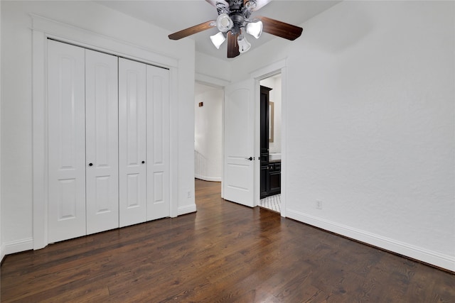 unfurnished bedroom featuring dark hardwood / wood-style flooring, ceiling fan, ensuite bath, and a closet