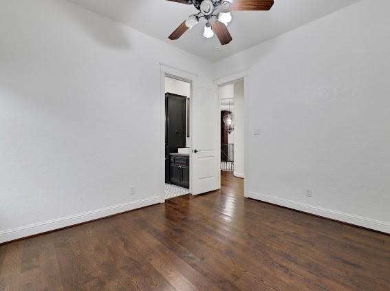 empty room featuring ceiling fan and dark hardwood / wood-style flooring