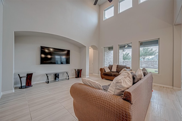 tiled living room featuring a high ceiling and ceiling fan