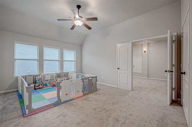 recreation room with vaulted ceiling, ceiling fan, and light colored carpet