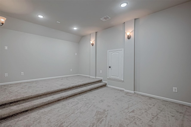 carpeted spare room featuring vaulted ceiling