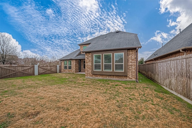 rear view of property featuring a yard