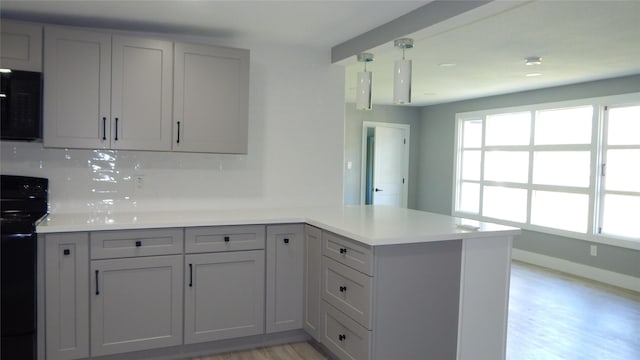 kitchen with electric range, gray cabinetry, and kitchen peninsula