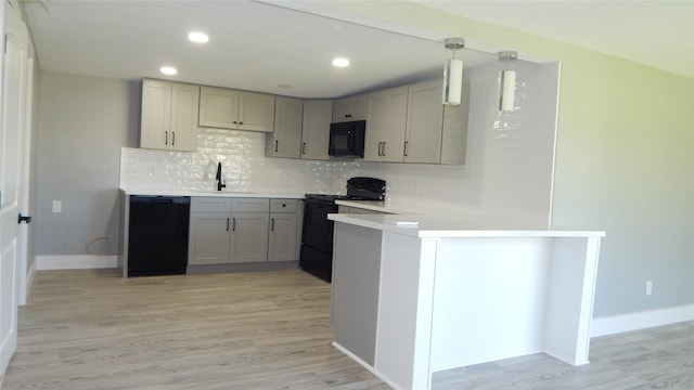 kitchen featuring sink, backsplash, decorative light fixtures, black appliances, and gray cabinets