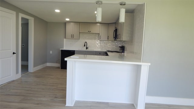 kitchen with pendant lighting, gray cabinetry, black appliances, kitchen peninsula, and decorative backsplash