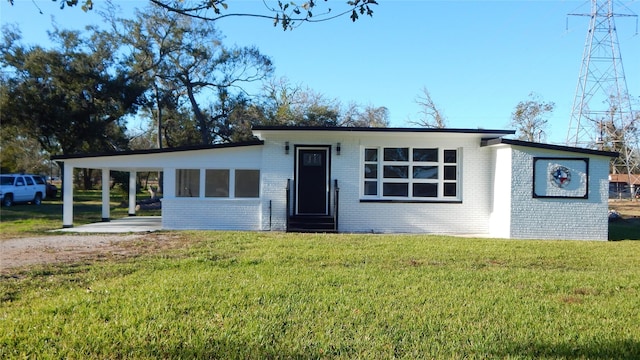 ranch-style house featuring a front lawn and a carport