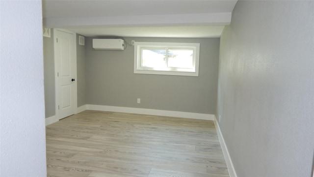 unfurnished room featuring light hardwood / wood-style flooring and a wall mounted AC